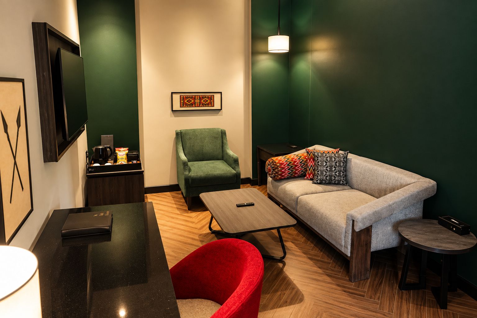 A modern hotel room with a sofa, armchair, and a small table.