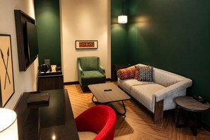 A modern hotel room with a sofa, armchair, and a small table. - Polo Hotel, Kohima (Kohima)