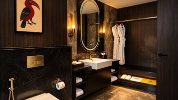 A modern bathroom with a large mirror, a sink, a toilet, and a shower area.