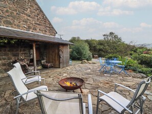 A stone patio with outdoor seating and a fire pit. - Waen Fechan (Dolgellau)