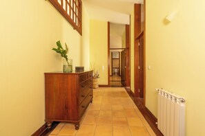 A hallway with a wooden dresser, a radiator, and a door leading to a bathroom. - Farmhouse - Beach, Pool and Jacuzzi with Sea View (Viana do Castelo)