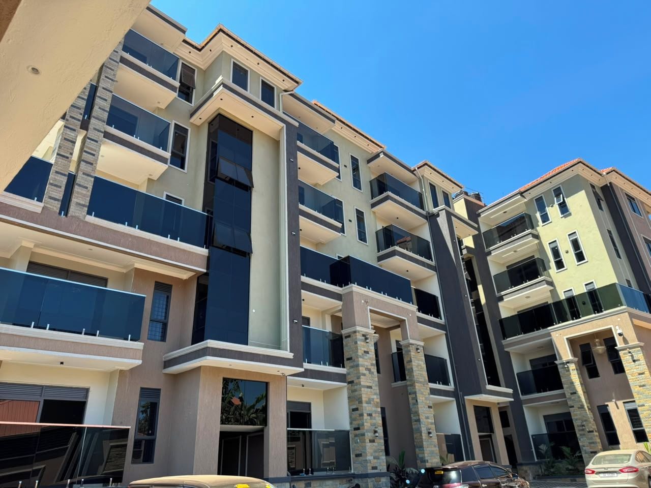 Un immeuble résidentiel à plusieurs étages, doté de balcons et d’une colonne centrale, avec un ciel dégagé.