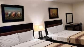 Habitación de hotel con dos camas, una mesita de noche, una lámpara y decoración en la pared.