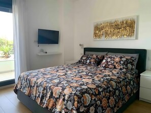 A bedroom with a bed, a television, a wall art piece, and a window with curtains. - Holiday Home 'Aurora' with Private Pool, Wi-Fi and Air Conditioning (Marčana)