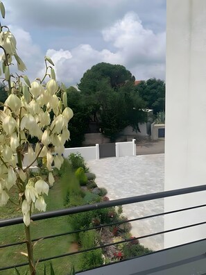 A balcony with a view of a garden, a white fence, and a tree. - Holiday Home 'Aurora' with Private Pool, Wi-Fi and Air Conditioning (Marčana)