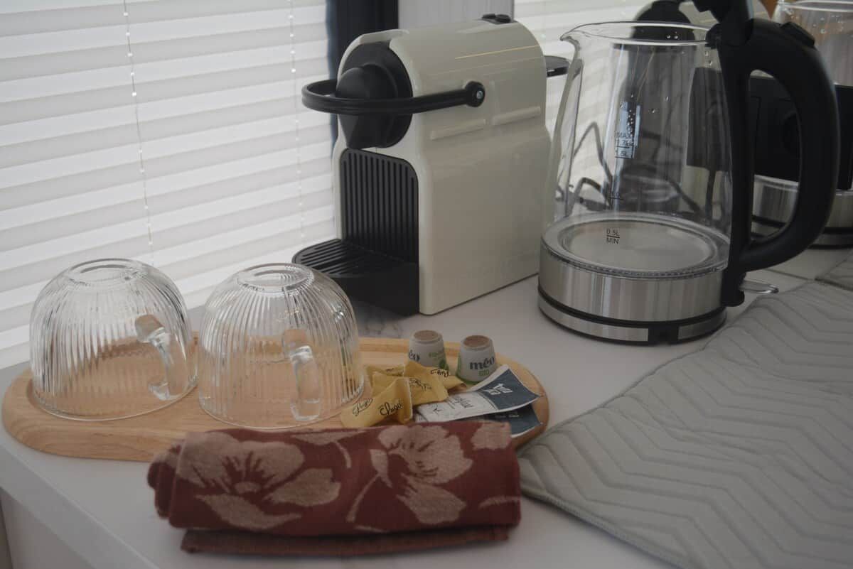 A kitchen counter with a coffee maker, a kettle, and a glass carafe.