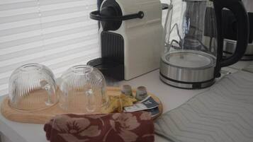 A kitchen counter with a coffee maker, a kettle, and a glass carafe.