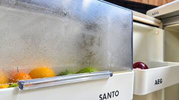A refrigerator with a glass door, containing fruits and vegetables.
