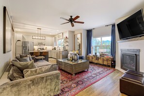 Un salon moderne avec un canapé, une table basse et une cheminée.