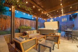 An outdoor patio with a grill, seating area, and string lights. - Red Rock Retreat | Hot Tub, EV Charger & Office (Colorado Springs)