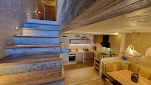Eine moderne Küche mit Einbauherd, Holzschränken und einem Essbereich mit Tisch und Stühlen.