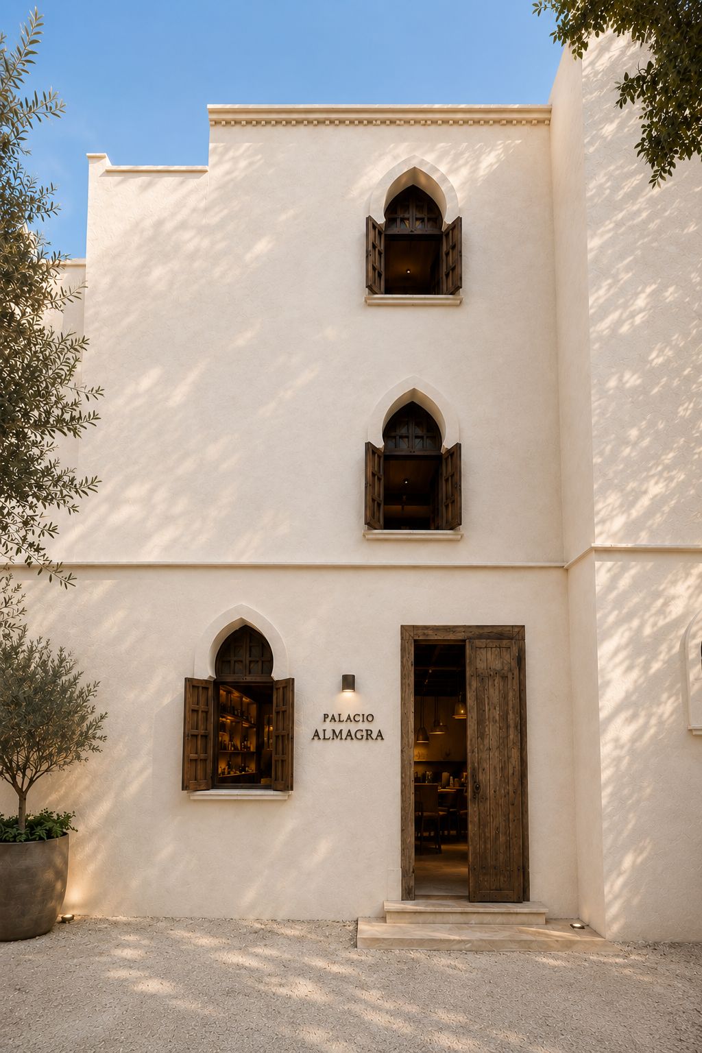 A building with a white facade, three arched windows, and a wooden door.