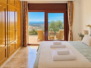 A hotel room with a bed, a balcony, and a view of the landscape. - Romantic designed stone house with pool & views (Palau-Saverdera)