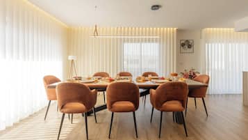 Un comedor moderno con una mesa larga, seis sillas y una lámpara colgante.