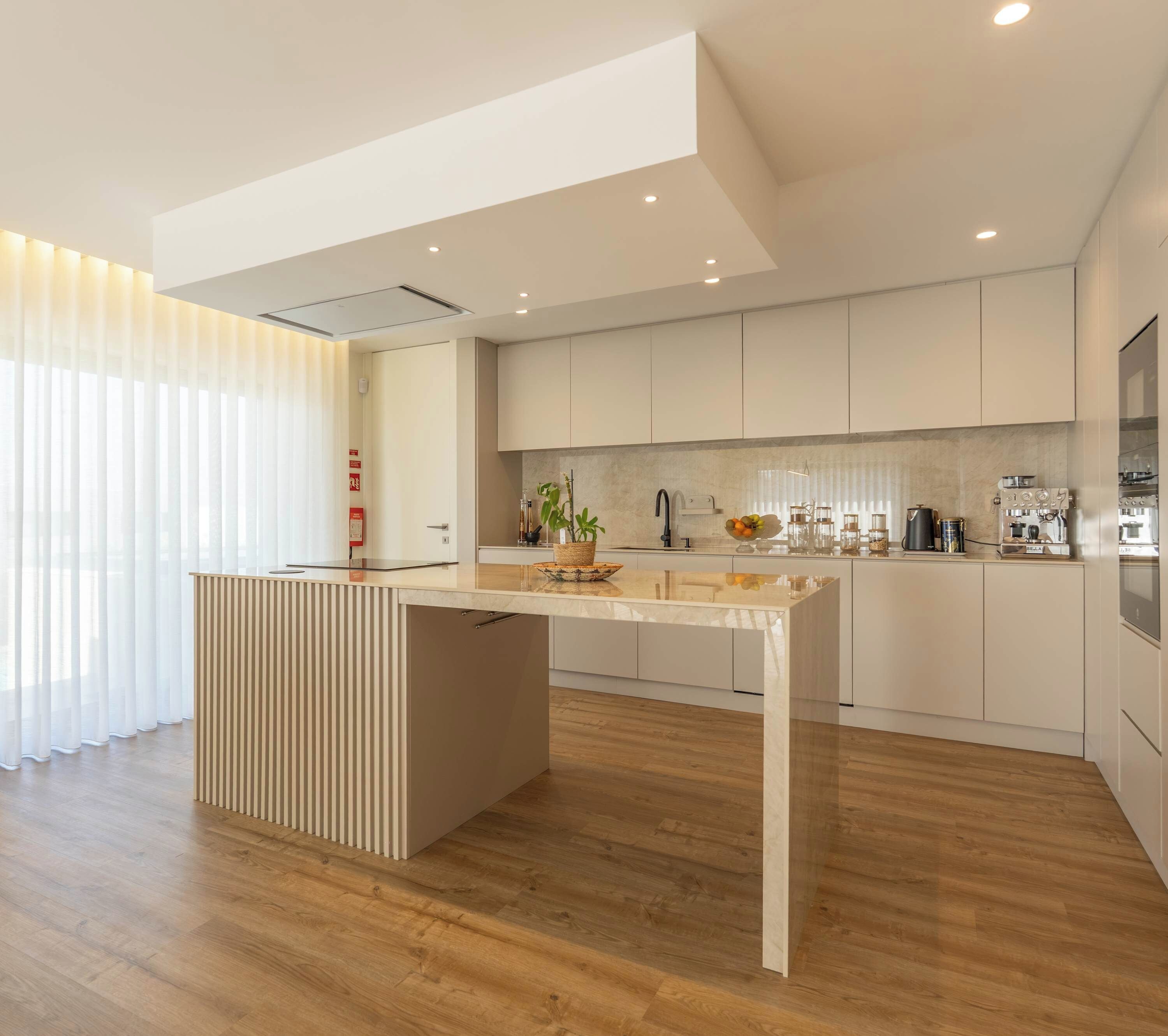 A modern kitchen with wooden flooring, a central island, and built-in cabinets.