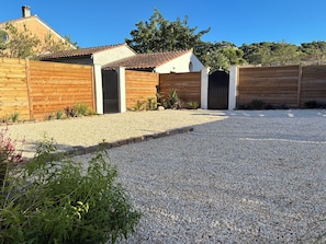 Una propiedad residencial con entrada de grava, cercas de madera y un portón.