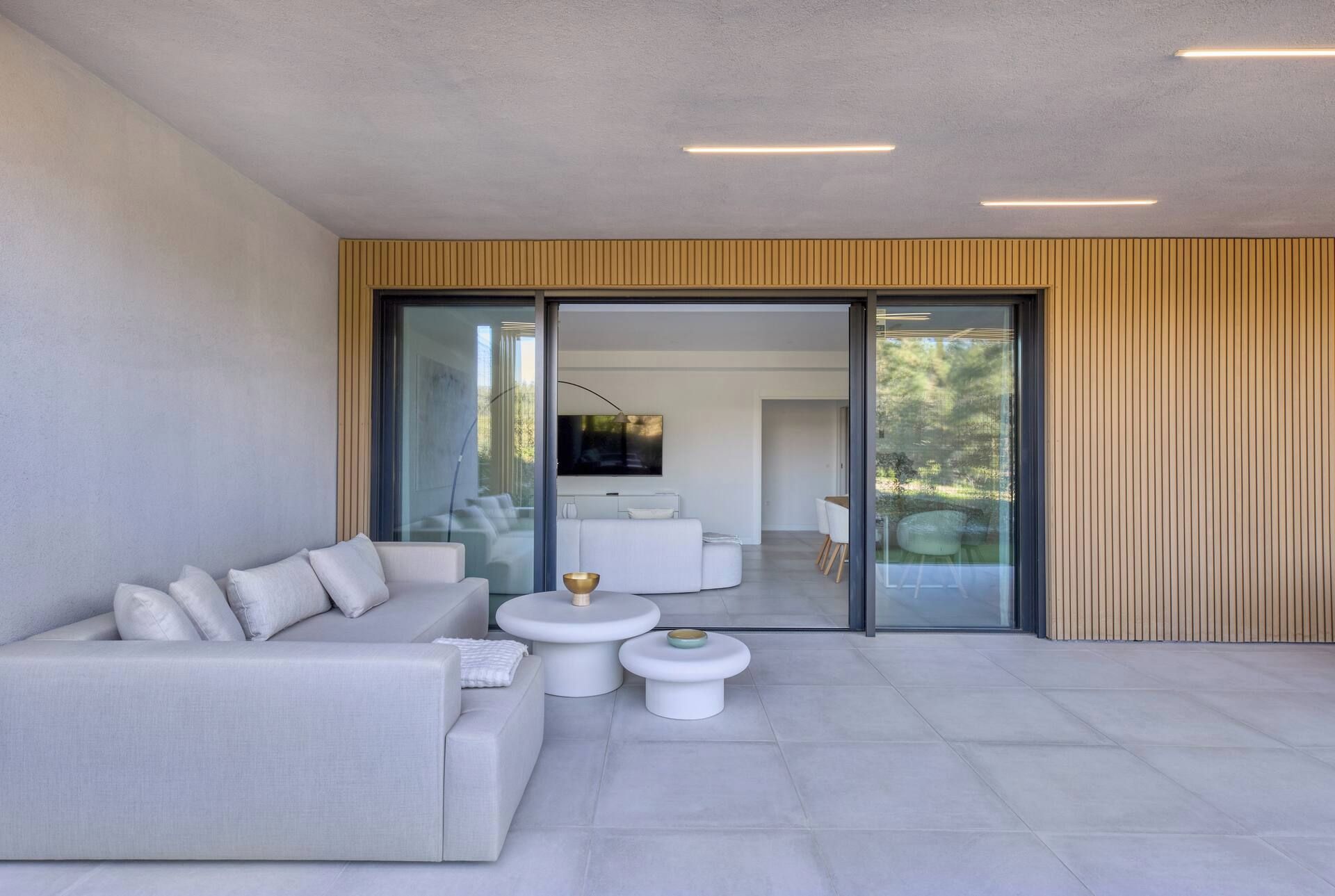 A modern living room with a sofa, coffee table, and a TV mounted on the wall.