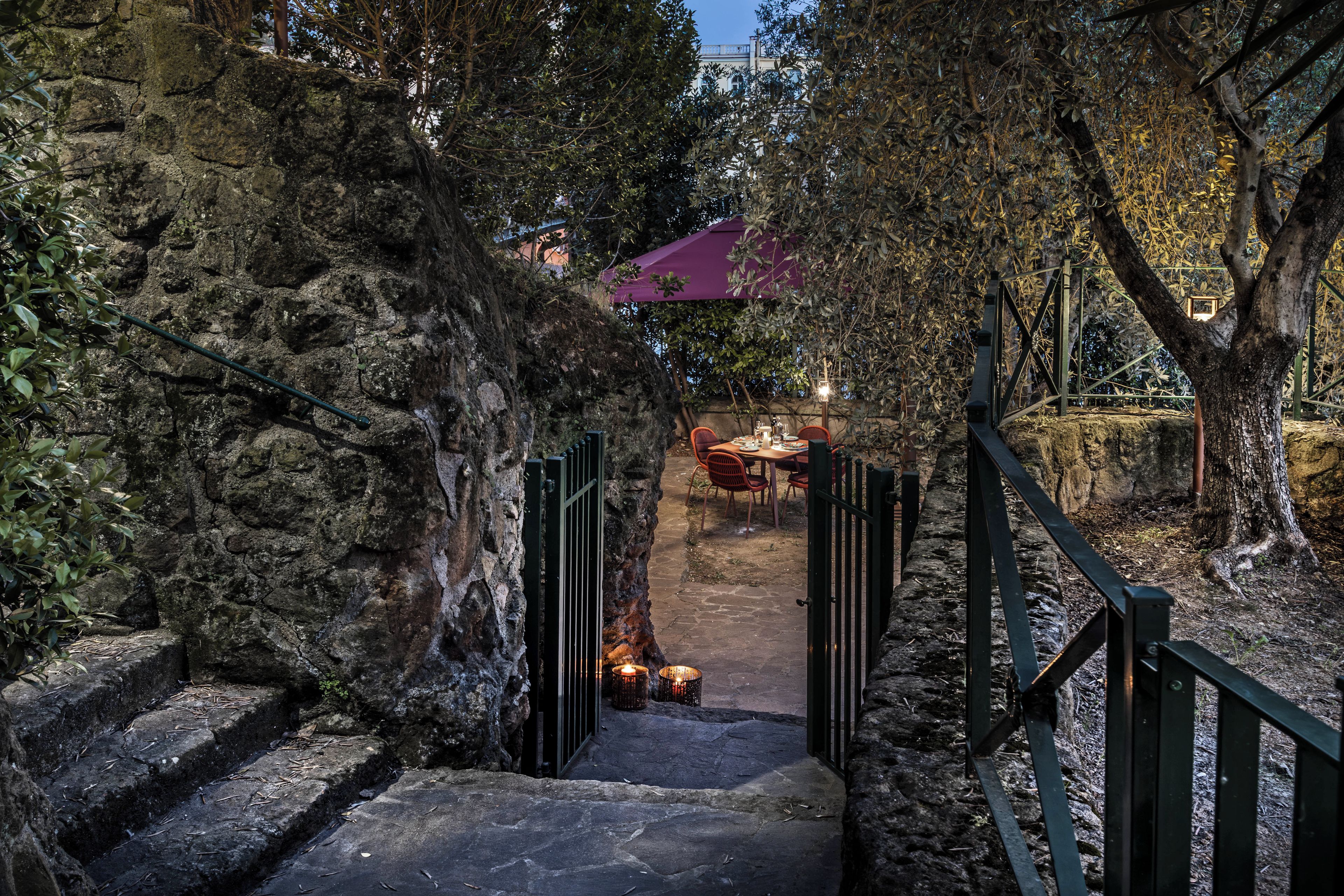 A stone staircase leading to an outdoor seating area with a table and chairs.