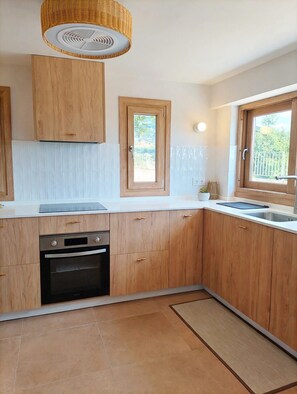 A kitchen with wooden cabinets, a built-in oven, a sink, and a window.
