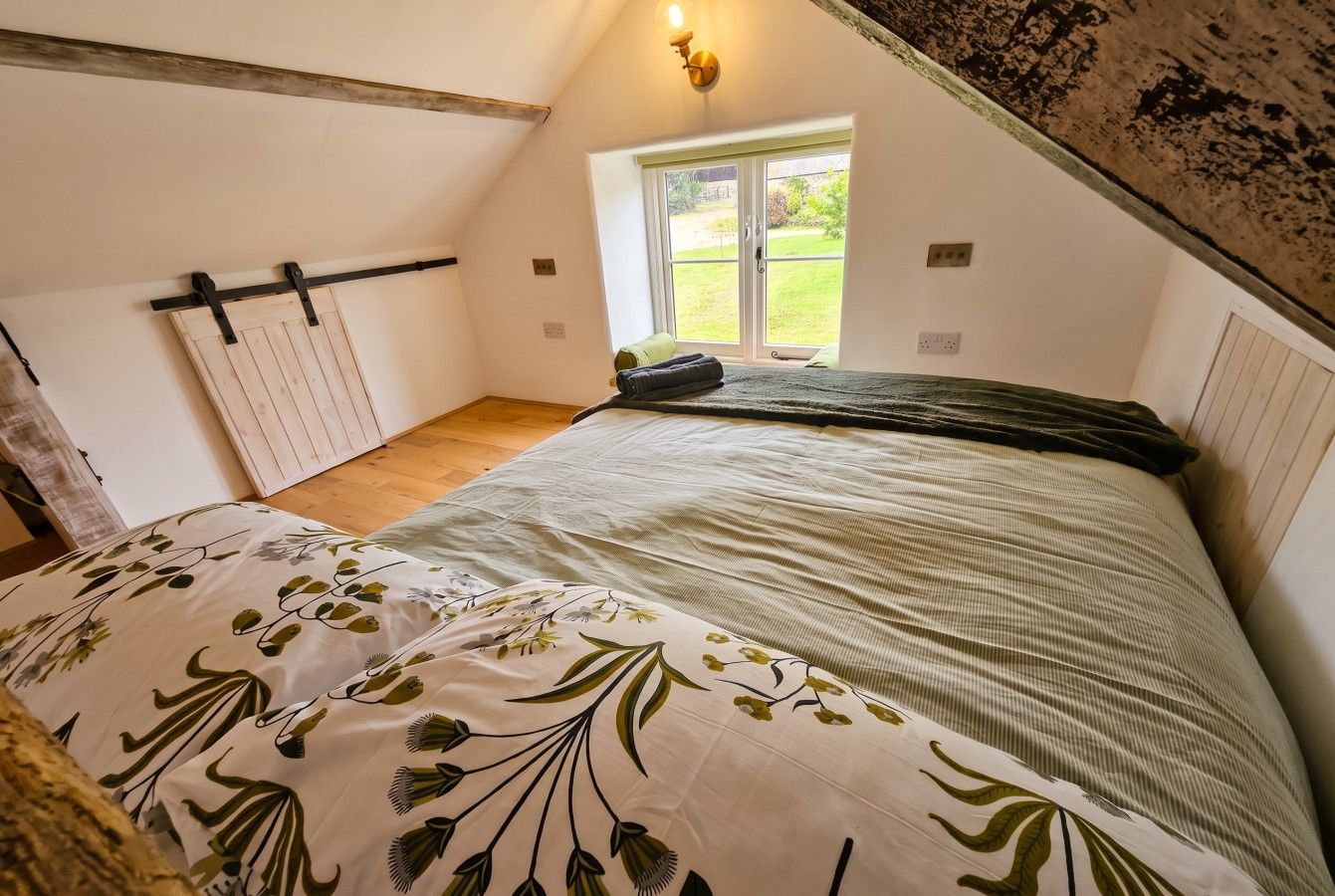A bedroom with a bed, a window, and a door.