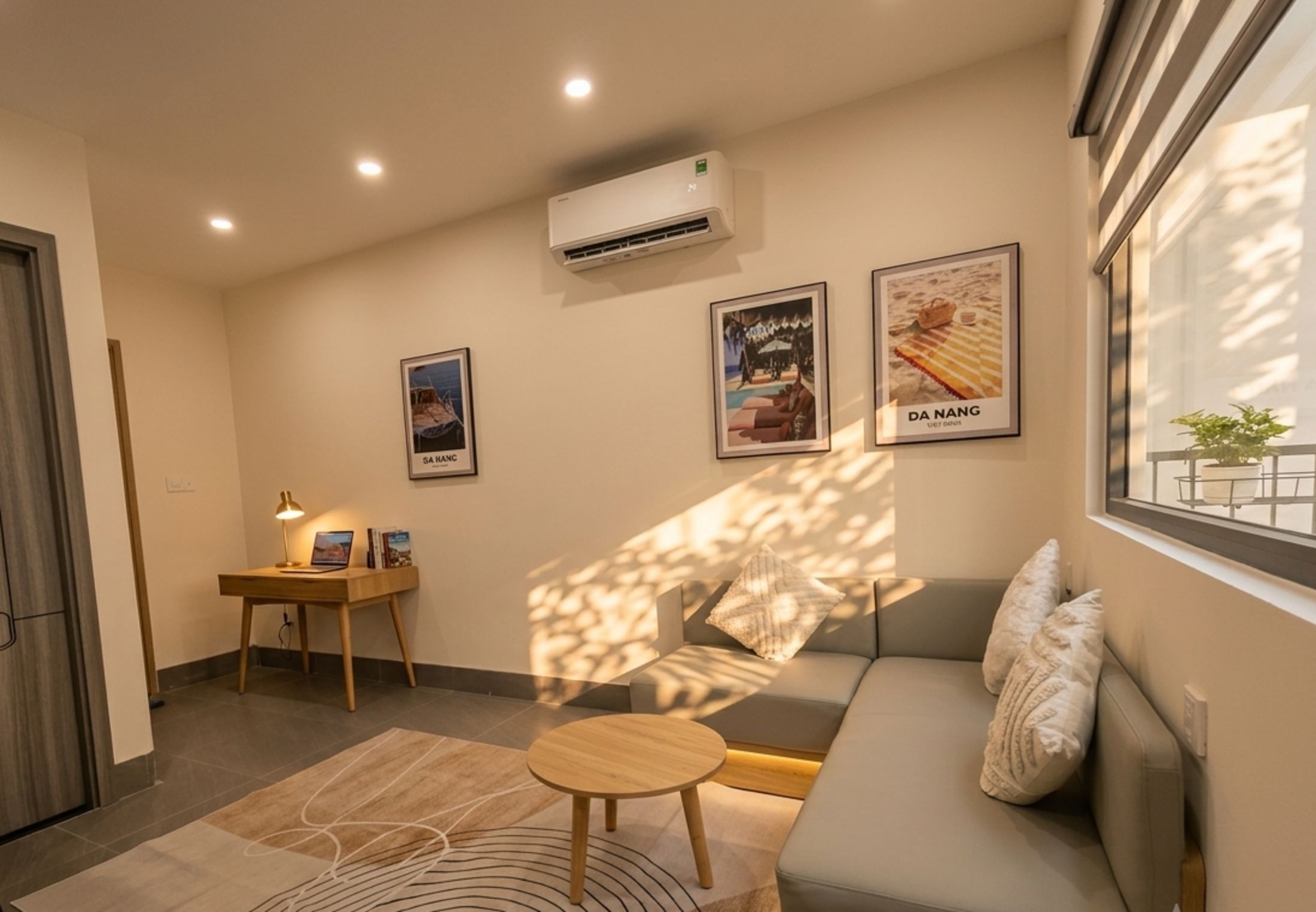A modern living room with a sofa, a small table, a lamp, and wall art.