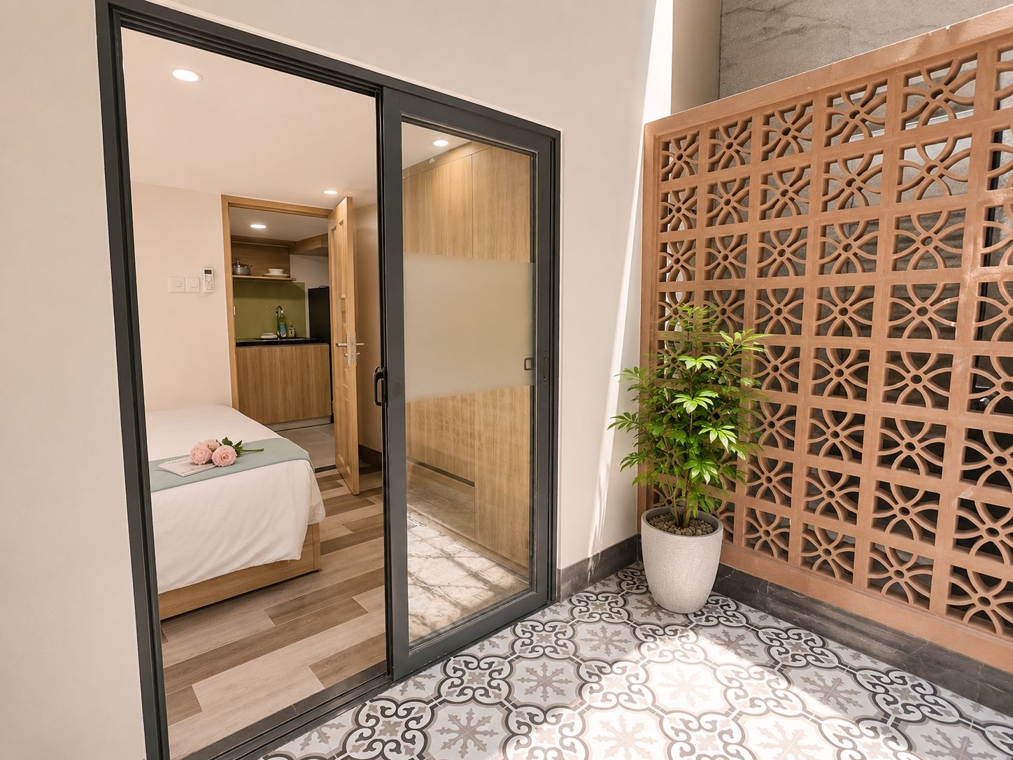 A room with a bed, a sliding door leading to a kitchen, and a decorative wooden partition.