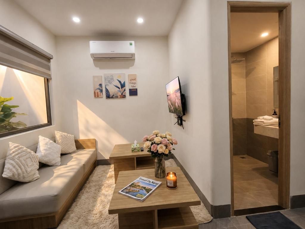 A modern bathroom with a shower, a sink, and a toilet. There is a wooden bench with a magazine and a candle.