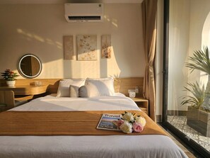 A hotel room with a bed, bedside table, a mirror, wall art, and a window with curtains. - Seascape Holiday Home (An Hai)