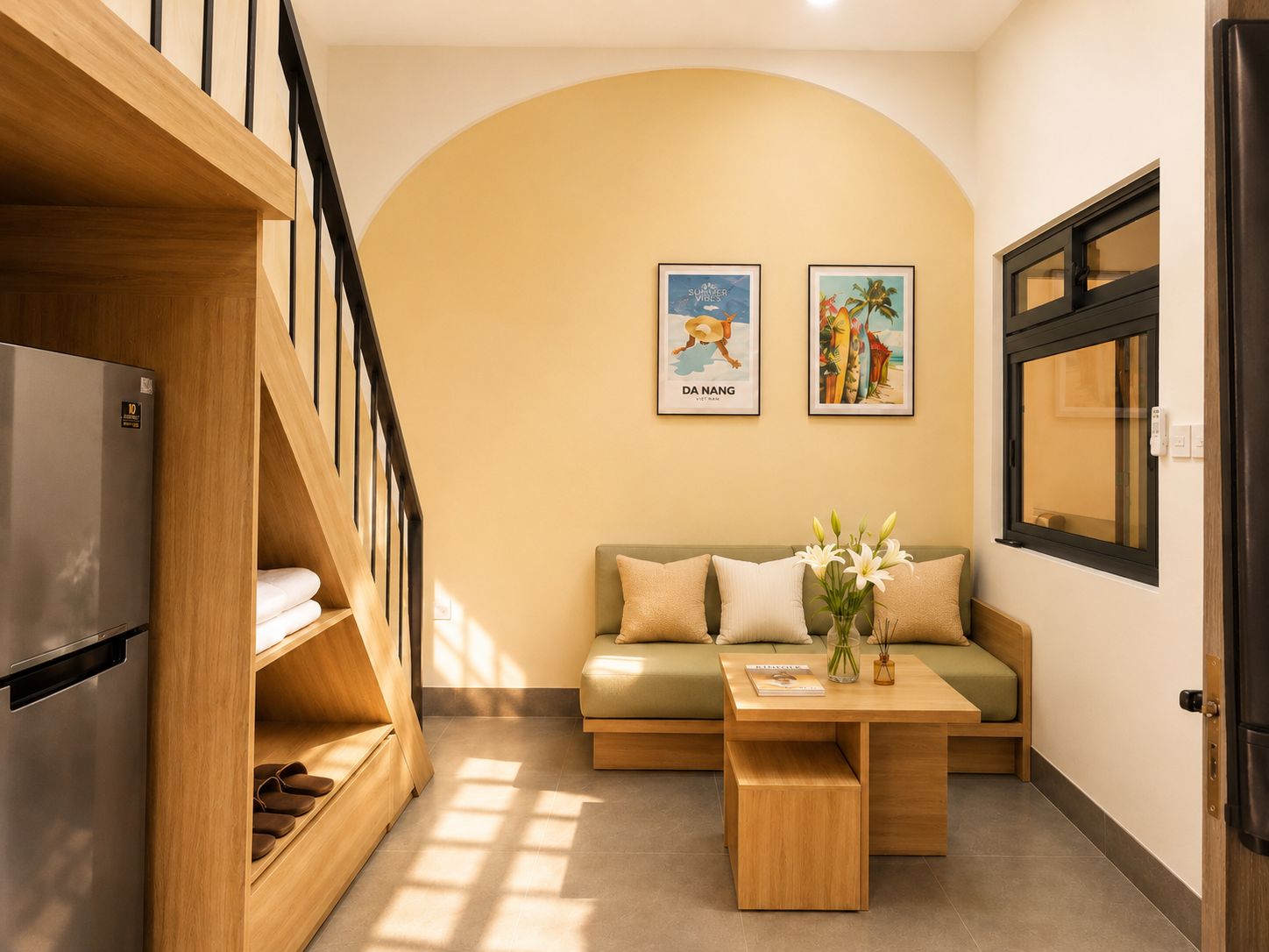 A modern interior with a wooden staircase, a sofa, a coffee table, and two framed pictures on the wall.