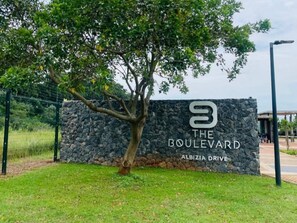 A stone wall with a sign for 'The Boulevard' on Albizia Drive. - Zimbali Boulevards (Ballito)