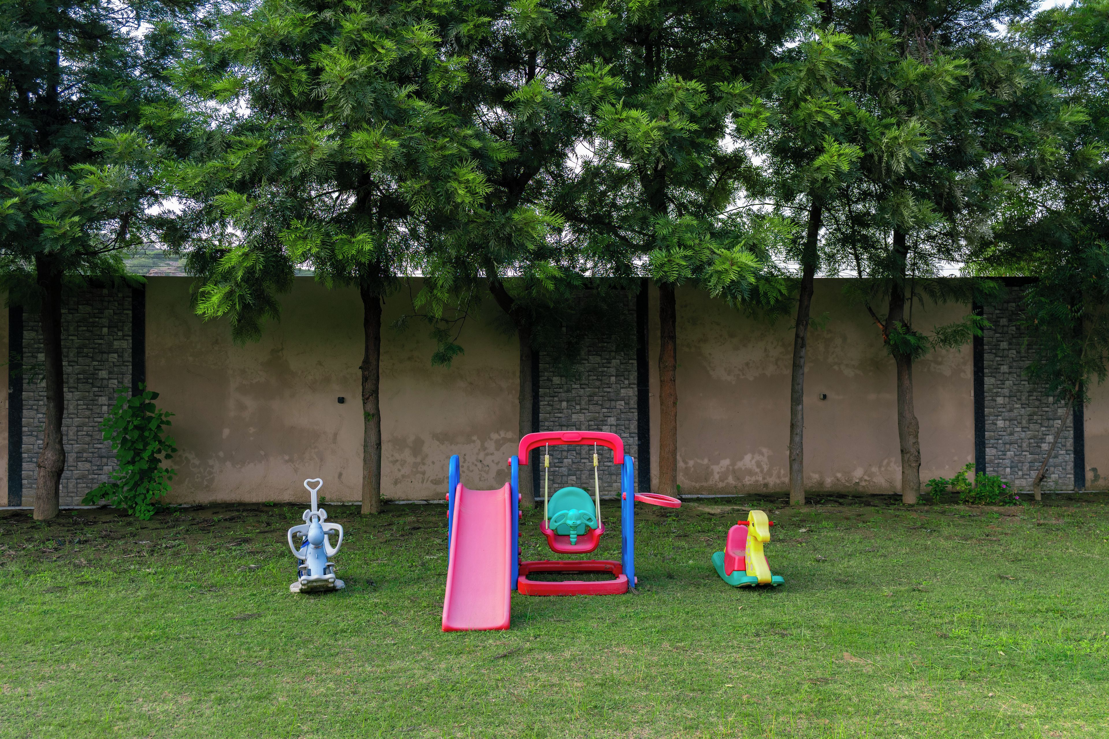 Een speeltuin met een glijbaan, schommel en klimrek.