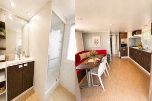 Eine moderne Küche mit dunklen Holzausziehtüren, ein Essbereich mit einer roten Couch und einer Duschkabine aus Glas.