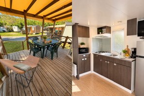 Eine Holzterrasse mit Tisch und Stühlen, einer gepolsterten Bank sowie einer Küche mit Schränken und Spüle.