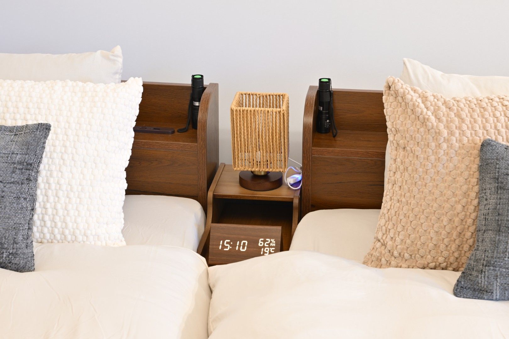 Un lit double avec deux tables de chevet, chacune équipée d’une lampe et d’une horloge.
