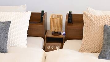 Un lit double avec deux tables de chevet, chacune équipée d’une lampe et d’une horloge.
