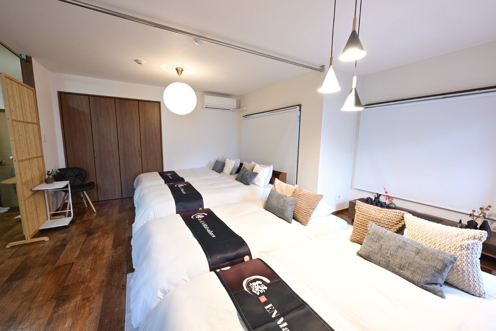A hotel room with a large bed, a desk, and a wardrobe.