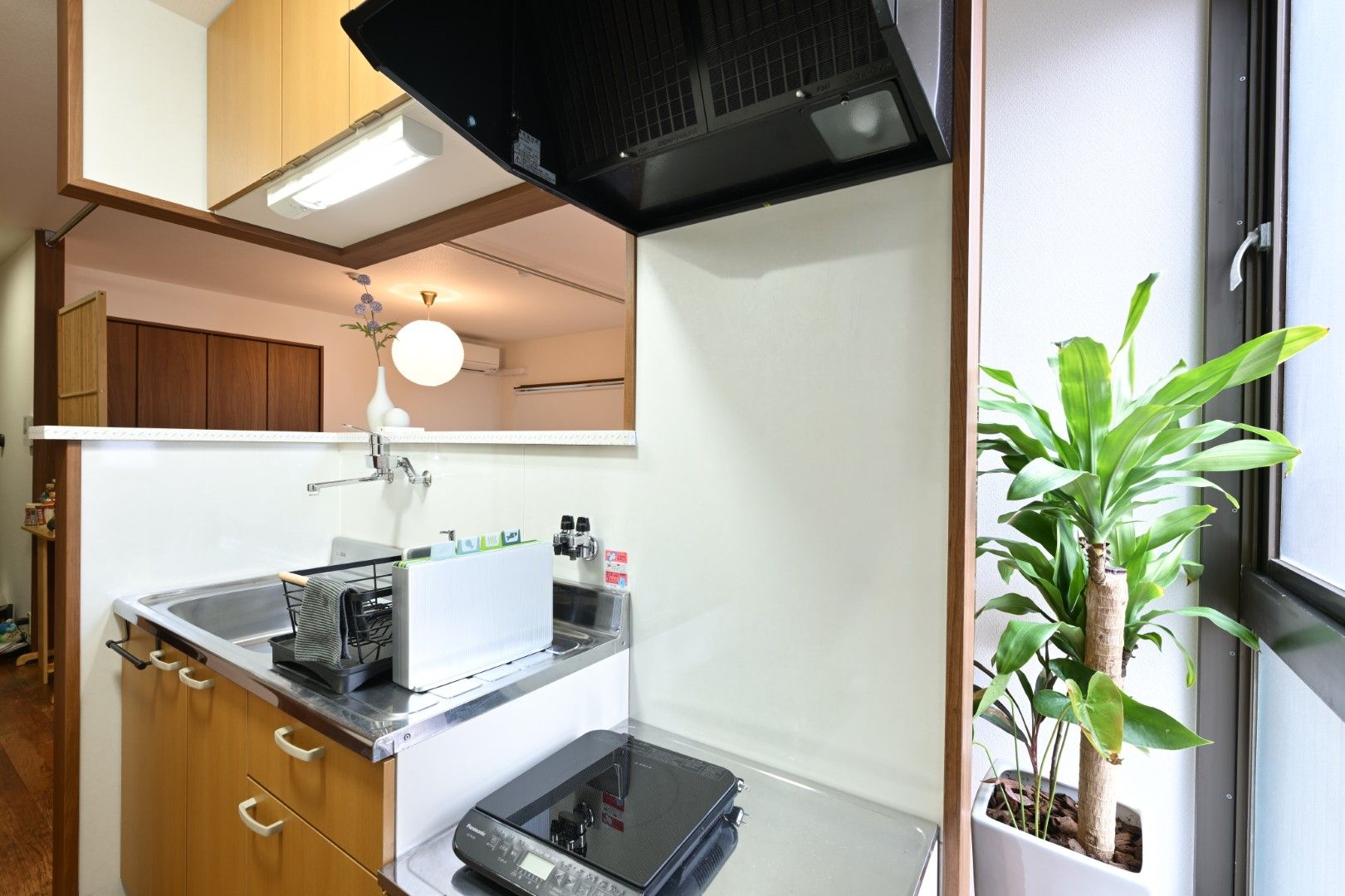 A compact kitchen with a microwave, sink, and cabinets.
