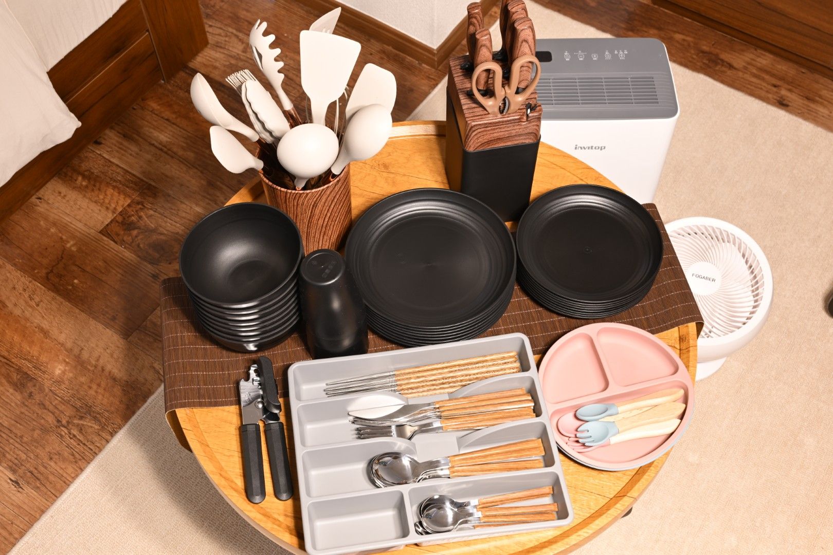 A kitchen setup with various utensils, plates, and a portable air cooler.