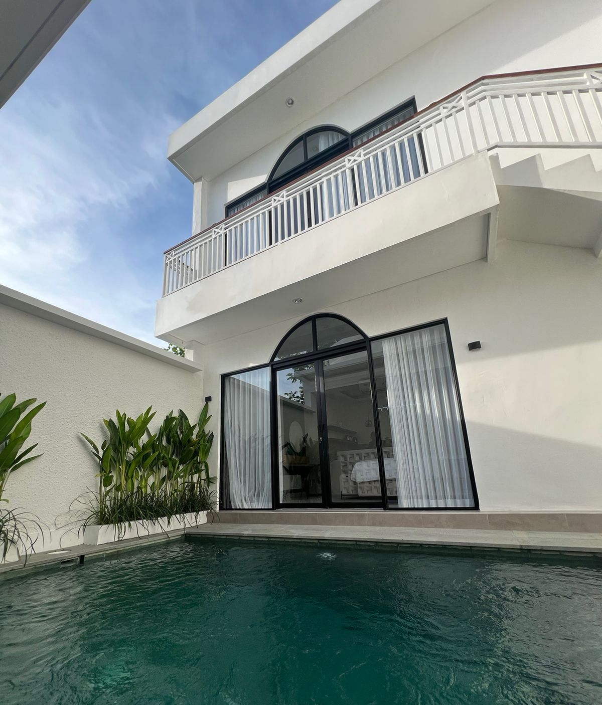 A modern two-story building with a swimming pool in the foreground.