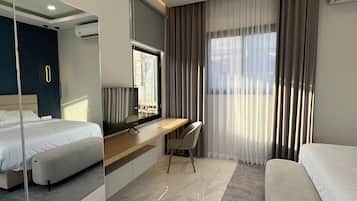 Una camera d'albergo moderna con un letto, una scrivania, una sedia e uno specchio grande.