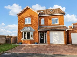 A two-story brick house with a garage, a bay window, and a front door. - Eyrie Heights (Whitby)