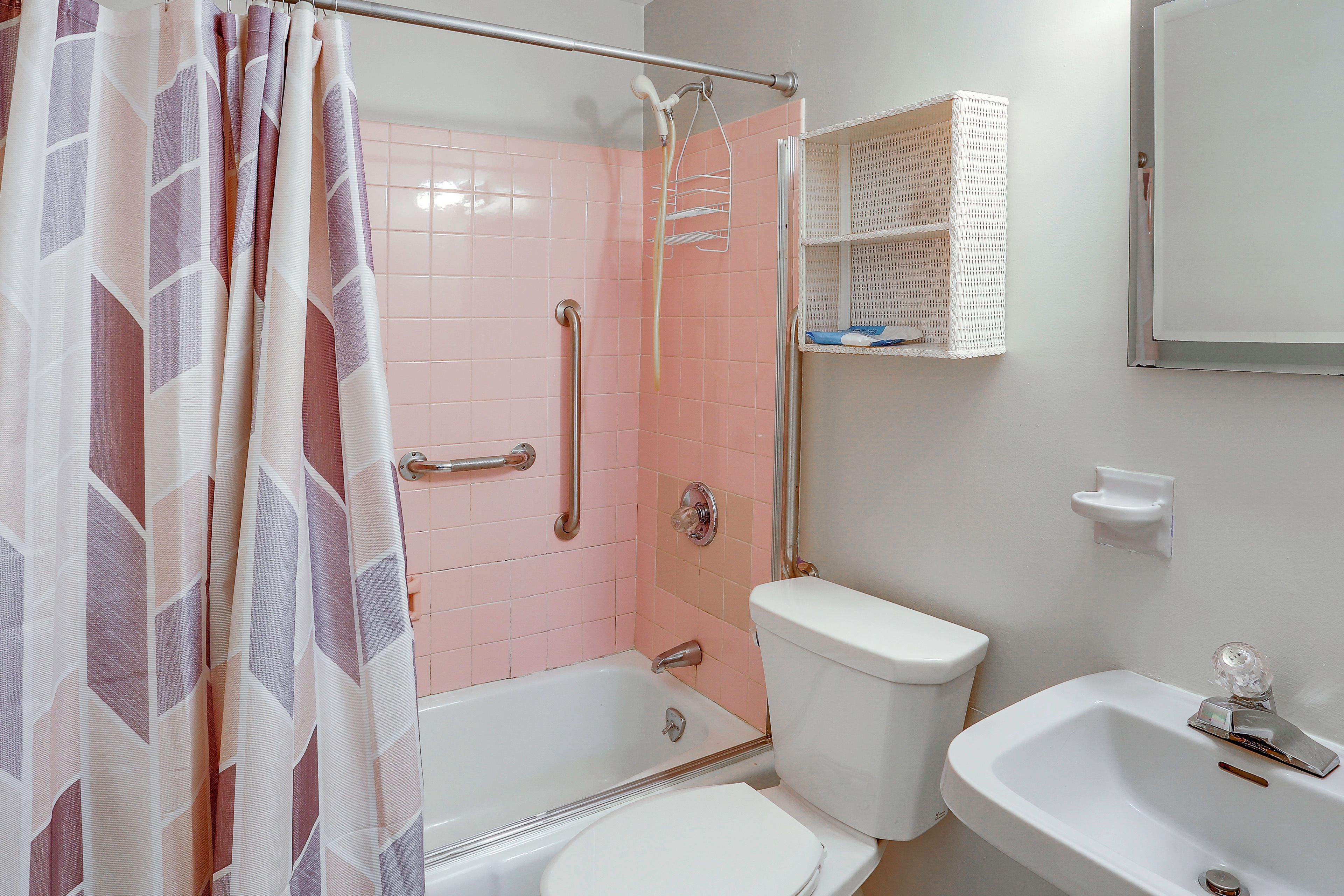 A bathroom with a shower, toilet, and sink.