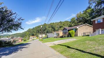 A residential street with houses, a clear sky, and power lines.