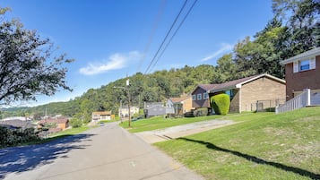 A residential street with houses, a clear sky, and power lines.