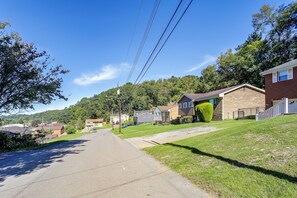 A residential street with houses, a clear sky, and power lines.