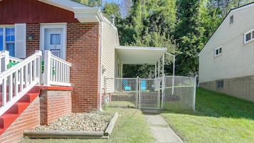 A residential property with a brick house, a covered porch, and a fenced yard.