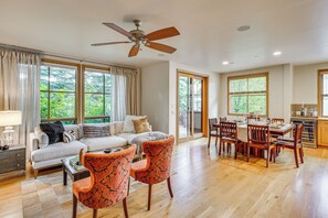 A spacious living area with a sofa, two patterned chairs, a dining table set for four, and a ceiling fan. - Sun Valley Extended Stay: Central Condo w/ Patio (Ketchum)
