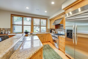 A modern kitchen with granite countertops, stainless steel appliances, and wooden cabinets. - Sun Valley Extended Stay: Central Condo w/ Patio (Ketchum)