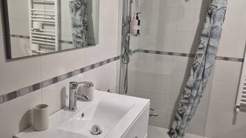 Ein Badezimmer mit Waschbecken, Spiegel und Dusche.