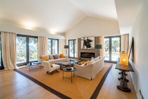 A spacious living room with a fireplace, large windows, and a modern design. - Cubo's Villa La Caldera / private pool / gym / vineyards / luxury experiences / free Wi-Fi (Ronda)
